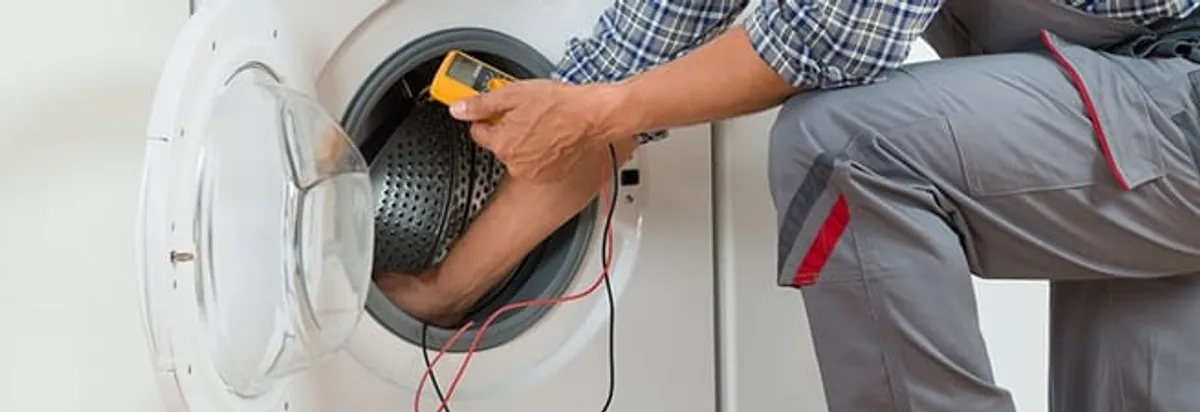Dryer repair technician inspecting and repairing a clothes dryer in Huntsville, AL