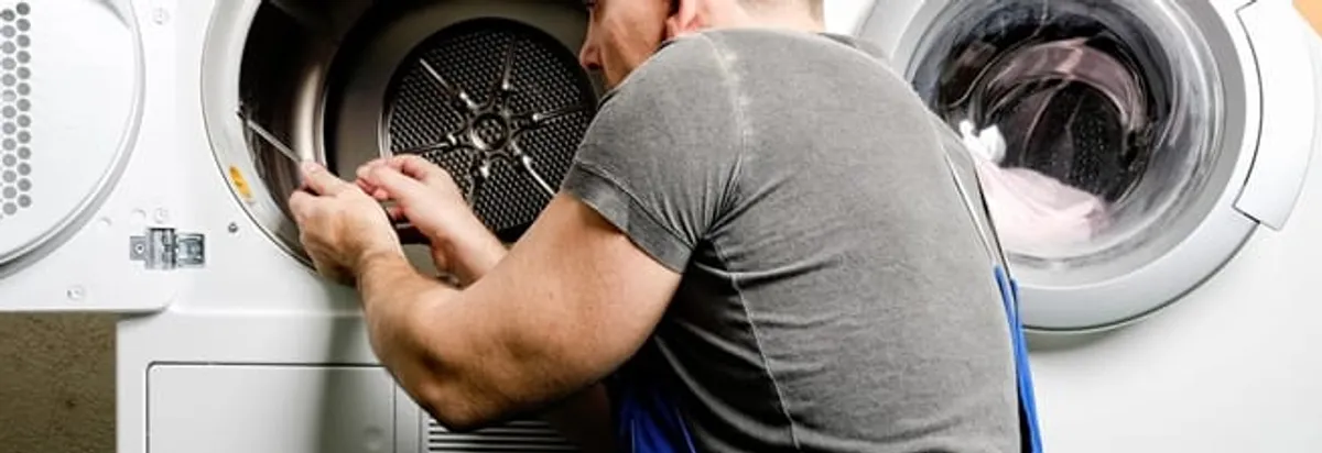 Dryer repair technician fixing a clothes dryer drum in Huntsville, AL