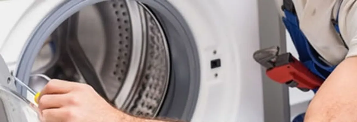 Appliance technician repairing a clothes dryer drum and internal parts in Huntsville, AL