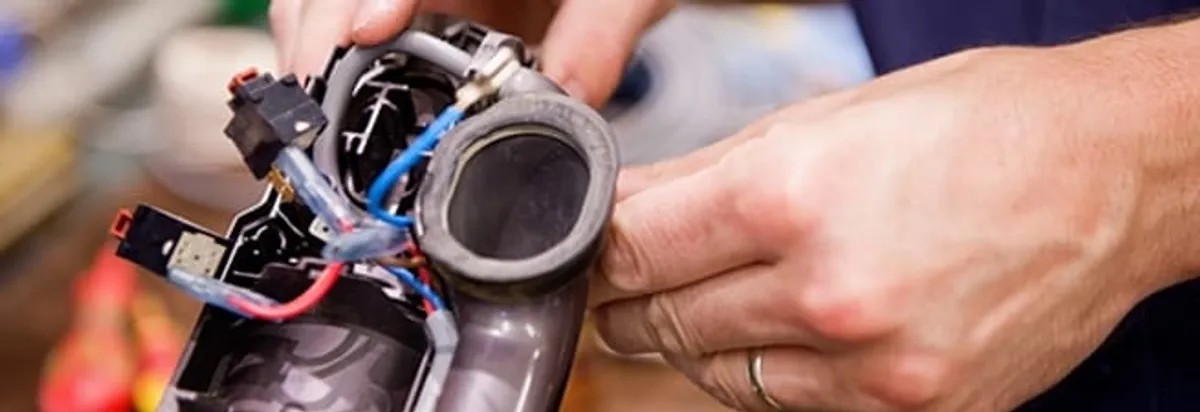 Vacuum repair technician reconnecting wiring and components in Huntsville, AL